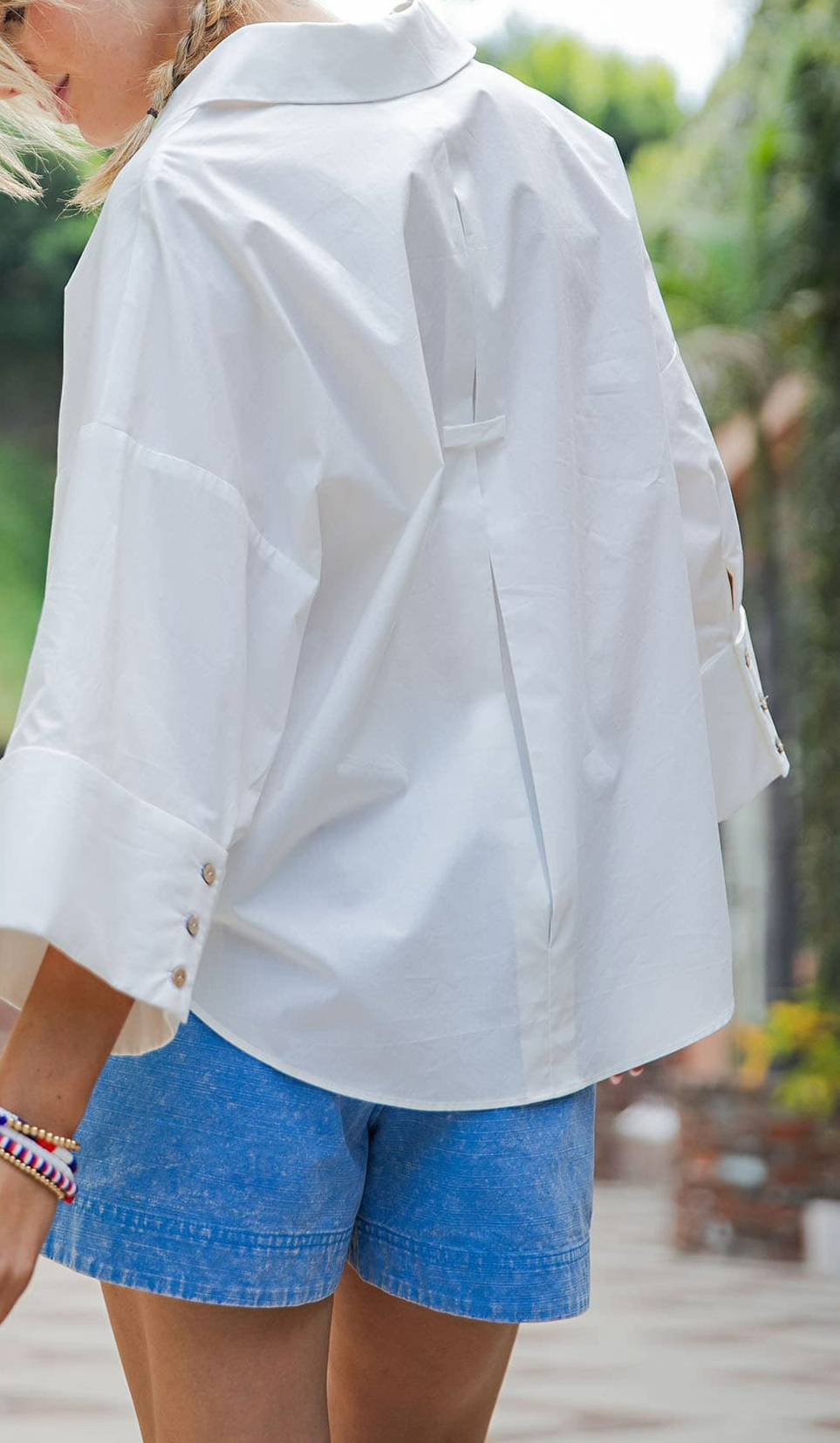 Button-down blouse showing the back pleat and relaxed fit through the shoulders